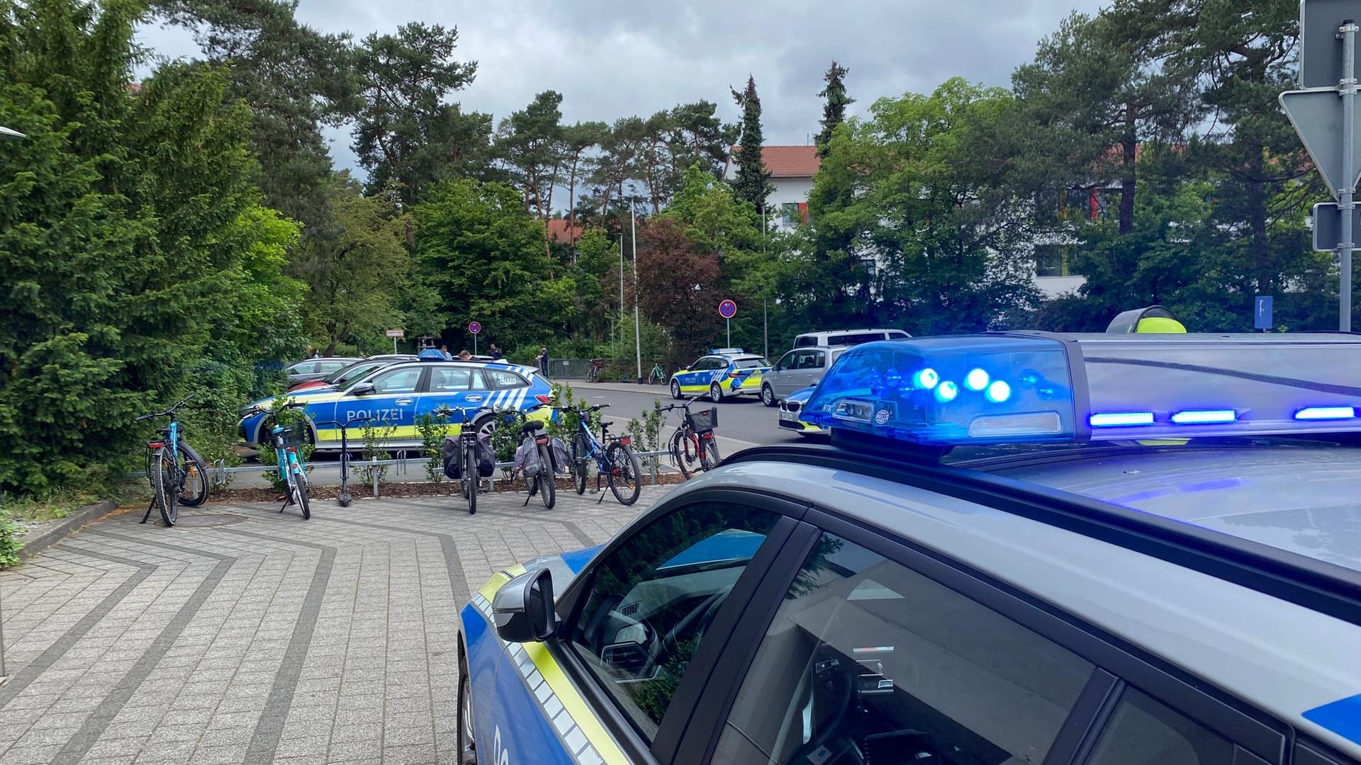 Polizeiautos stehen vor der Schule: Die Beamten rückten mit einem Großaufgebot an. Polizeiautos stehen vor der Schule: Die Beamten rückten mit einem Großaufgebot an.