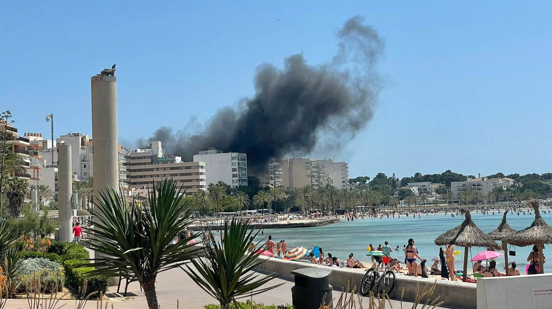 Rauchschwaden über dem Badeort S'Arenal in Mallorca, Spanien: Die vom Feuer getroffene Bar "Why not" liegt nahe der Strandpromenade.