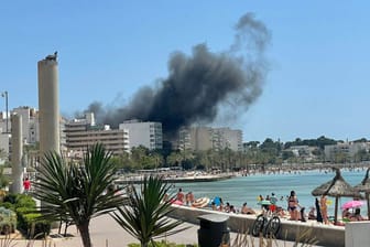 Rauchschwaden über dem Badeort S'Arenal in Mallorca, Spanien: Die vom Feuer getroffene Bar "Why not" liegt nahe der Strandpromenade.