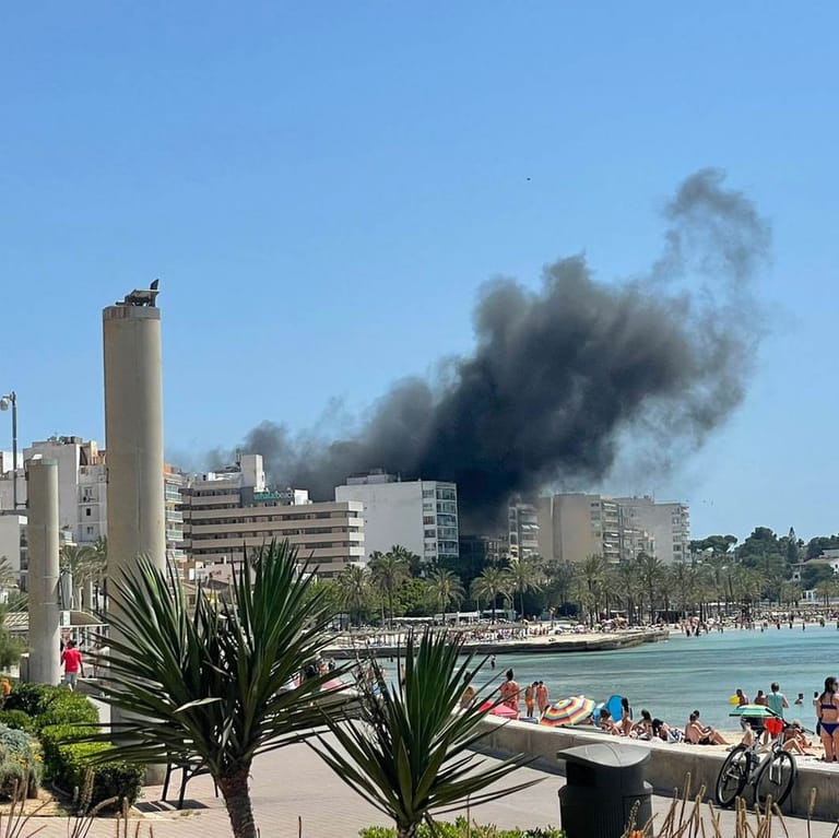 Rauchschwaden über dem Badeort S'Arenal in Mallorca, Spanien: Die vom Feuer getroffene Bar "Why not" liegt nahe der Strandpromenade.