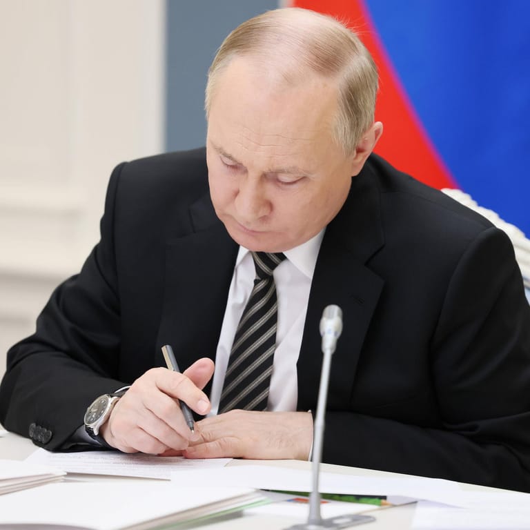 Wladimir Putin schaut auf Dokumente (Archivbild): Der russische Präsident will über Getreideexporte verhandeln.