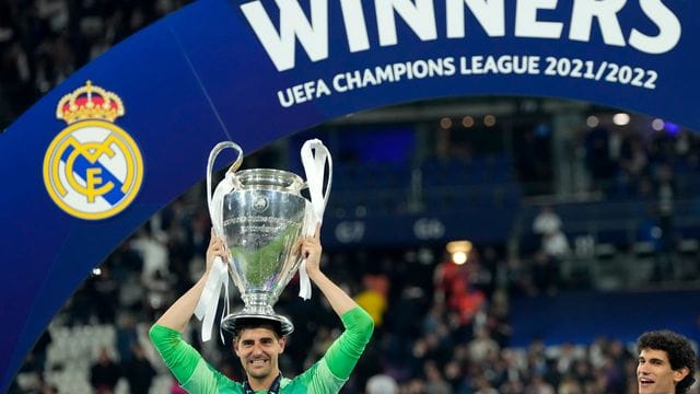 Real Madrids Torhüter Thibaut Courtois balanciert die Trophäe nach dem Sieg auf seinem Kopf.