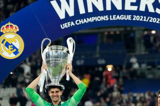 Real Madrids Torhüter Thibaut Courtois balanciert die Trophäe nach dem Sieg auf seinem Kopf.