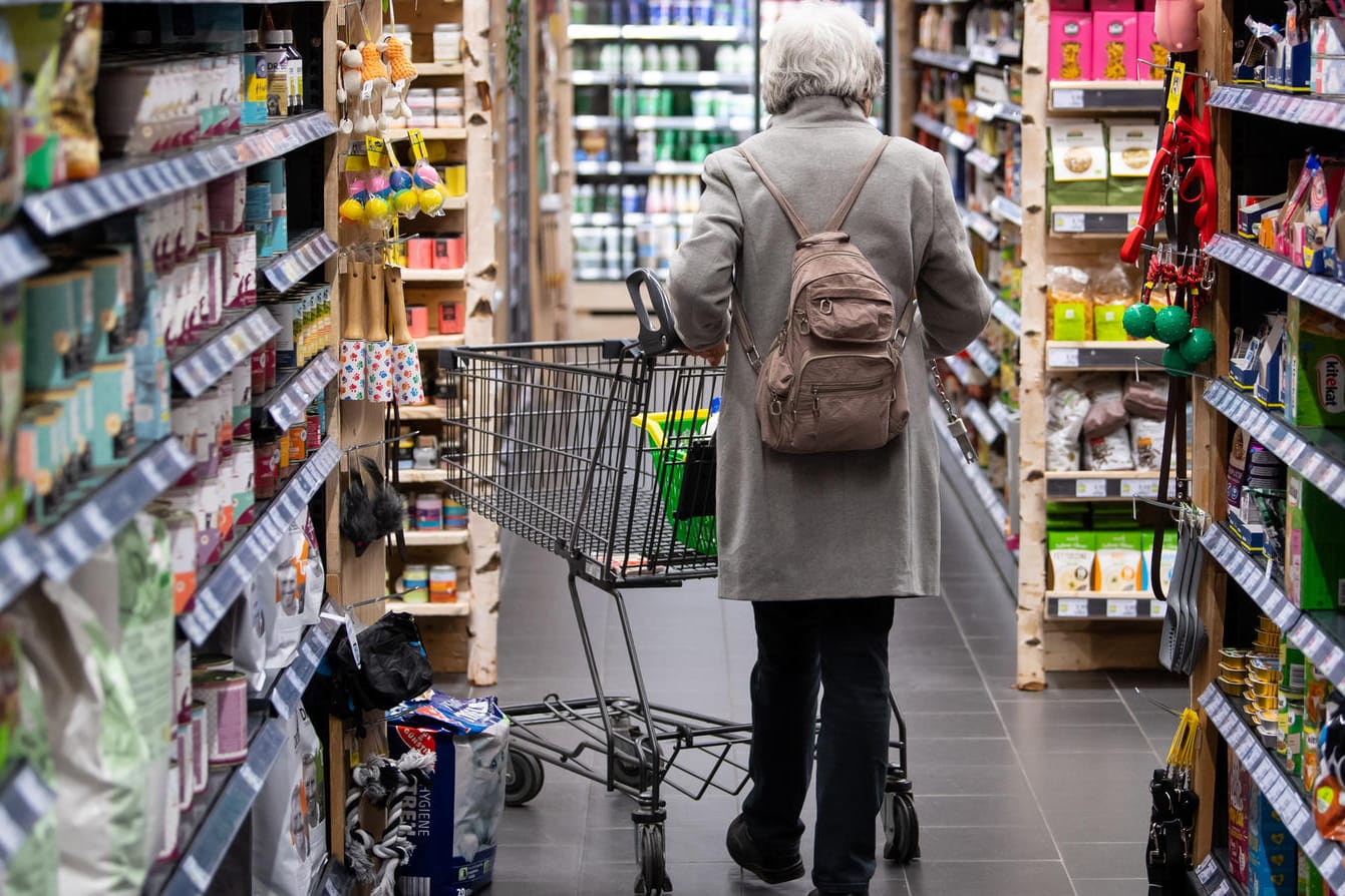 Eine Frau geht mit ihrem Einkaufswagen durch einen Supermarkt (Symbolbild): Die Menschen in Deutschland müssen für Lebensmittel in den nächsten Monaten wahrscheinlich noch einmal deutlich mehr bezahlen.