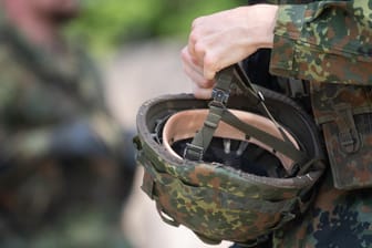 Ein Reservist in Ausbildung hält seinen Helm: Die Soldaten sollen vollständig mit Bekleidung ausgestattet werden.