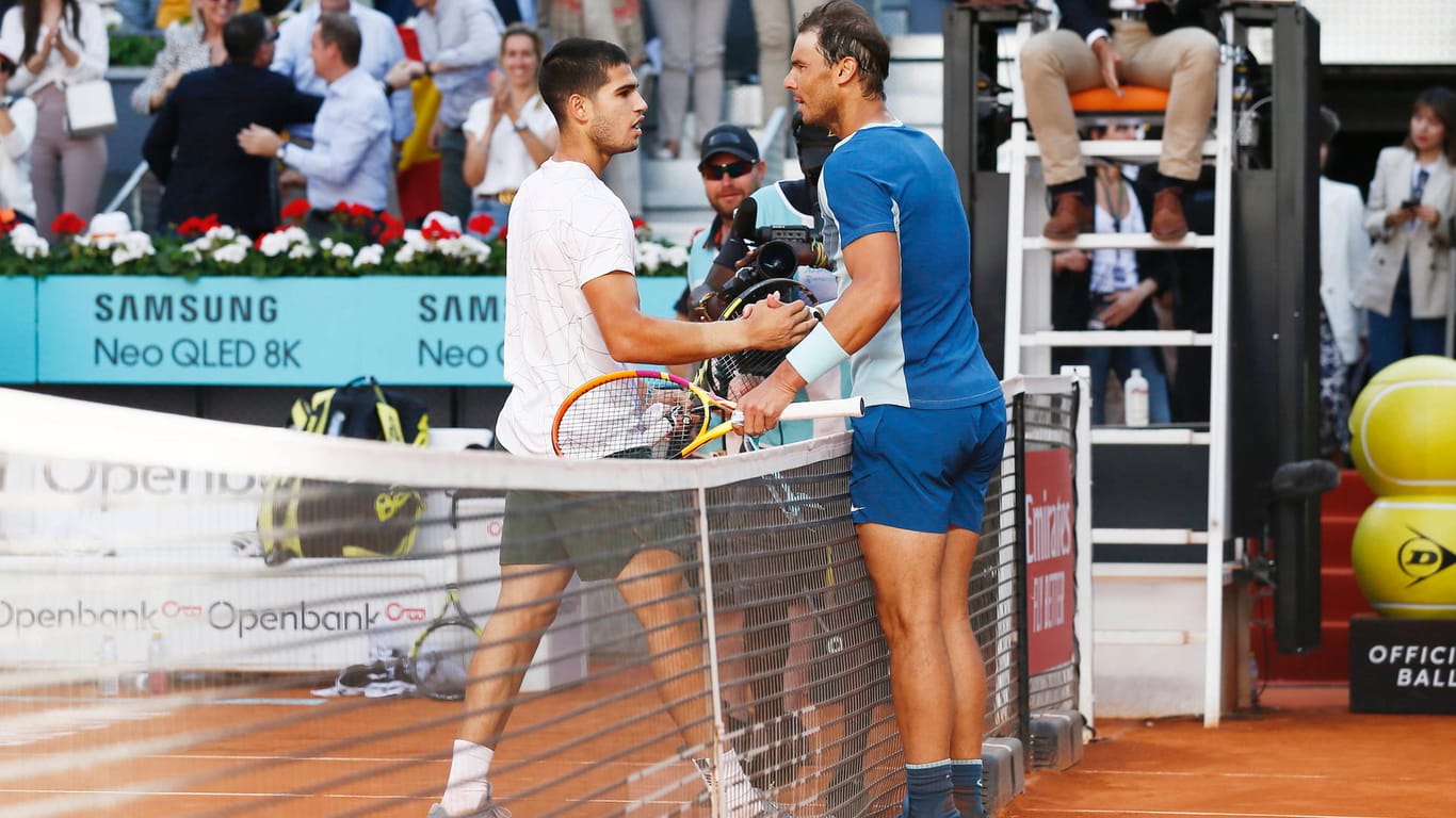Kein Nervenflattern vor dem eigenen Idol: Carlos Alcaraz wird nach seinem Sieg im Generationenduell in Madrid von Rafael Nadal beglückwünscht.