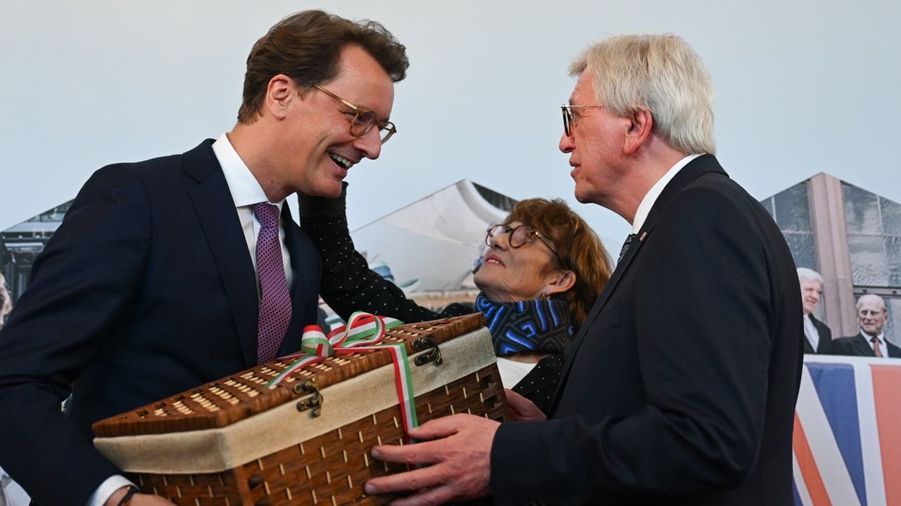 NRW-Ministerpräsident Hendrik Wüst überreicht dem scheidenden hessischen Ministerpräsidenten Volker Bouffier einen Korb. NRW-Ministerpräsident Hendrik Wüst überreicht dem scheidenden hessischen Ministerpräsidenten Volker Bouffier einen Korb.