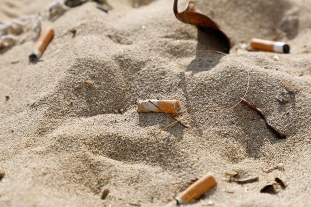 Zigarettenstummel verschmutzen den Strand von Arenal auf der spanischen Urlaubsinsel Mallorca.