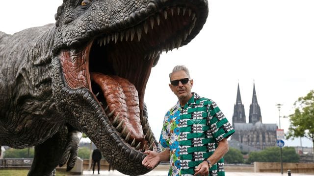 Jeff Goldblum vor einer T-Rex Figur in Köln.