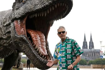 Jeff Goldblum vor einer T-Rex Figur in Köln.