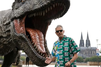 Jeff Goldblum vor einer T-Rex Figur in Köln.