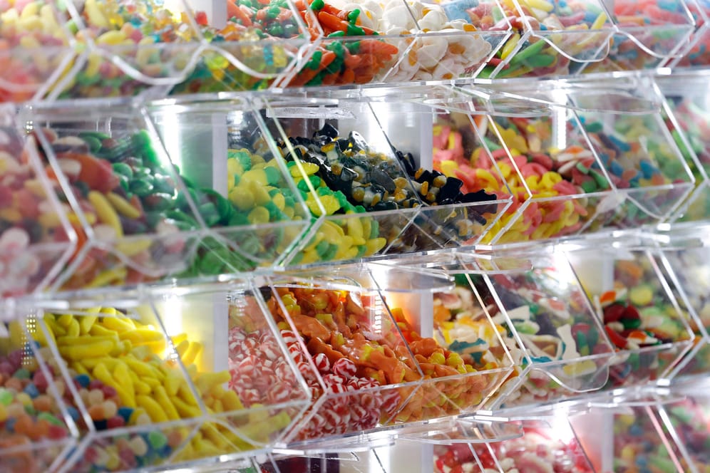 Süßwaren in Plastikbehältern (Symbolbild): Süßigkeiten und fehlende Bewegung führen zu Gewichtszunahme.