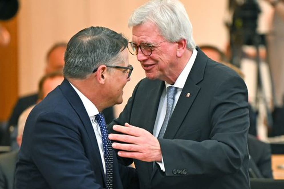 Neuer und alter Regierungschef: Boris Rhein (l) nimmt im Plenarsaal des hessischen Landtags die Glückwünsche seines Amtsvorgängers Volker Bouffier entgegen.