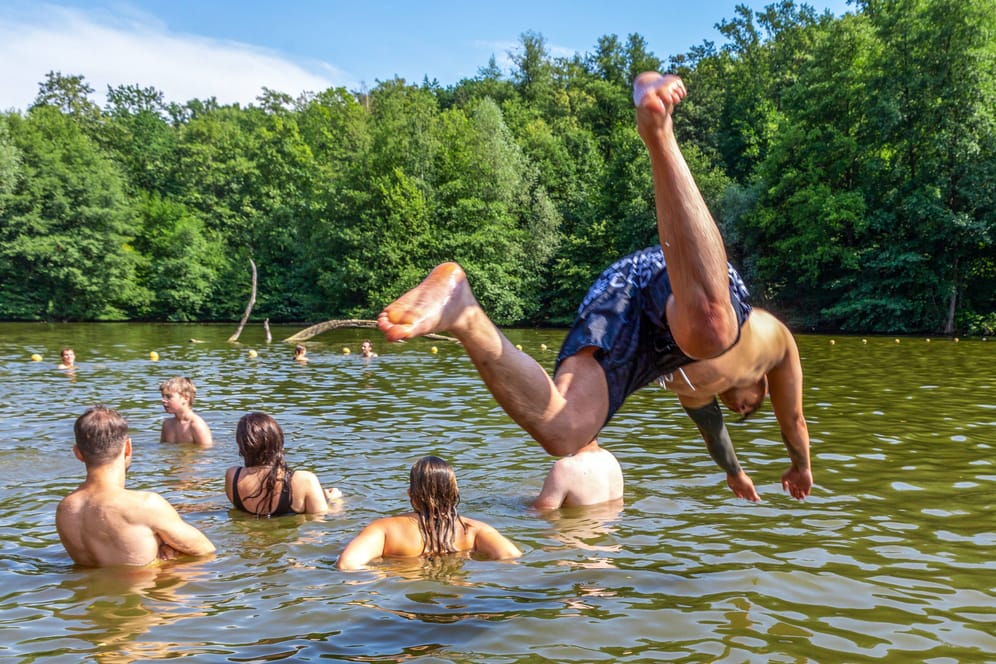 Eine Person springt in einen Badesee (Symbolbild: Auch rund um Hamburg gibt es zahlreiche Gewässer, an denen das Baden erlaubt ist.