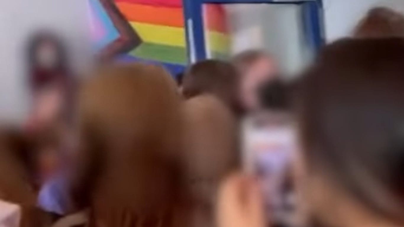Ausschnitt aus dem Video: Dutzende Schüler bedrängen die Mädchen mit der Regenbogenfahne.
