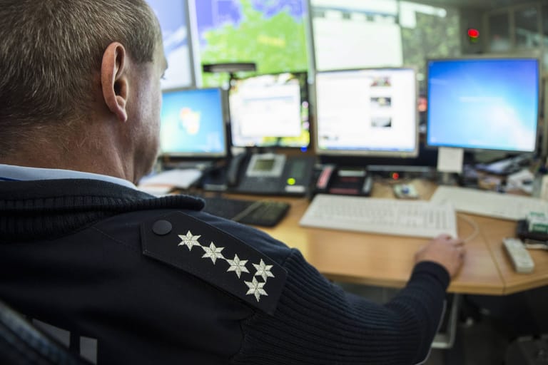 Ein Polizist sitzt vor dem Computer (Symbolbild): Die ausführliche Polizeidatenbank Poliks wird von Beamtinnen und Beamten immer wieder für private Zwecke missbraucht.