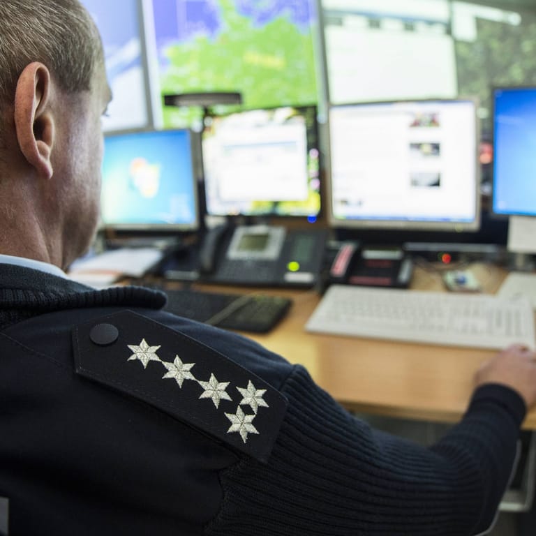 Ein Polizist sitzt vor dem Computer (Symbolbild): Die ausführliche Polizeidatenbank Poliks wird von Beamtinnen und Beamten immer wieder für private Zwecke missbraucht.
