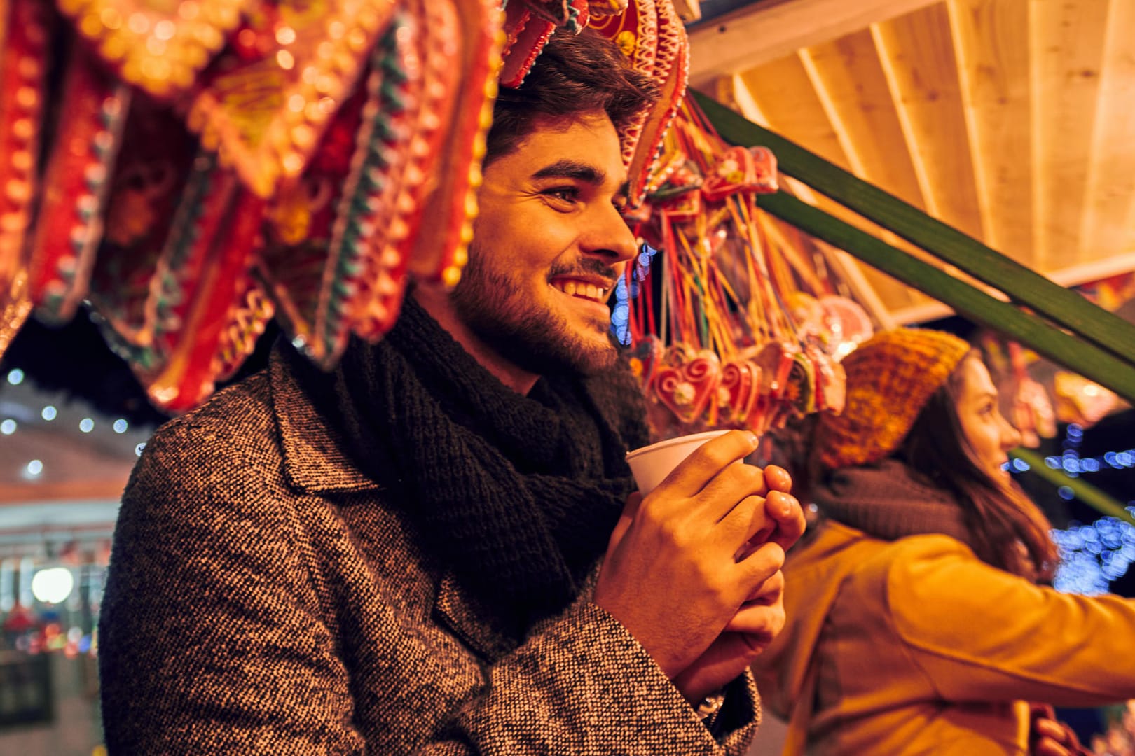 Mann auf dem Weihnachtsmarkt: Zu den absoluten Kalorienbomben auf dem Weihnachtsmarkt gehören Eierpunsch und Glühwein. Es gibt aber kalorienärmere Alternativen.