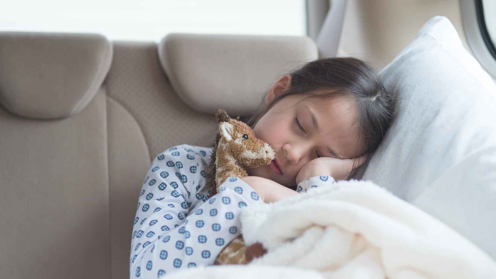 Lieblingsstofftier und Kuscheldecke: Sie erleichtern Kindern die lange Autofahrt.