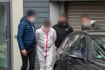Polizisten bringen einen der Tatverdächtigen aus dem Justizgebäude in Kaiserslautern: Ein Mann soll geschossen haben, ein weiterer war mit ihm auf der Flucht.