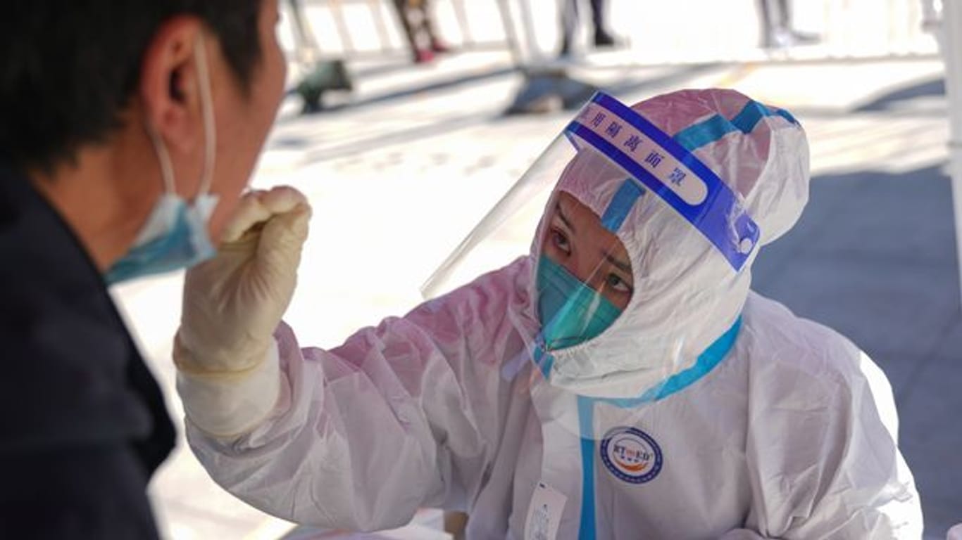 Eine medizinische Angestellte testet einen Anwohner in Pekings Bezirk Daxing auf das Coronavirus.