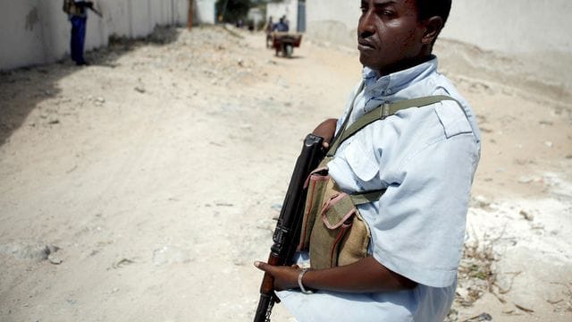 Ein schwer bewaffnetet Soldat hält in Mogadischu Wache: Die Terrorgruppe Al-Schaabab verübt immer wieder Anschläge auf Sicherheitskräfte und Zivilisten.