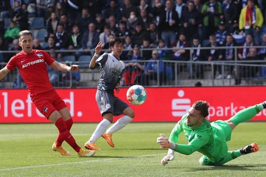 Berlins Torwart Marcel Lotka (r) pariert einen Ball von Bielefelds Masaya Okugawa (2.