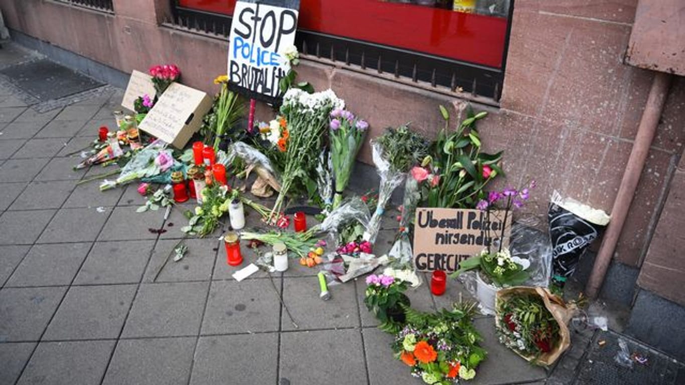 Blumen, Kerzen und Schilder liegen an dem Ort, an dem am Montag (02.