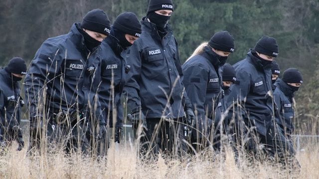 Polizeibeamte suchen auf einer Wiese Spuren, nachdem in der Nähe eine 16-Jährige tot aufgefunden worden ist. Polizeibeamte suchen auf einer Wiese Spuren, nachdem in der Nähe eine 16-Jährige tot aufgefunden worden ist.