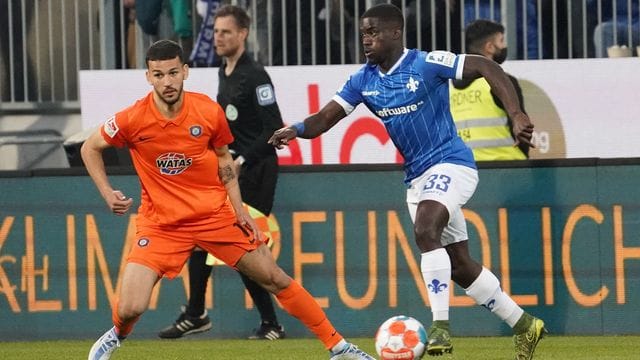 Soufiane Messeguem (l) von Erzgebirge Aue in Aktion gegen Braydon Manu (r) von Darmstadt 98.