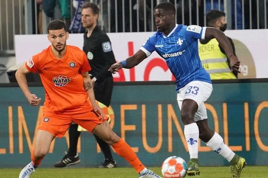 Soufiane Messeguem (l) von Erzgebirge Aue in Aktion gegen Braydon Manu (r) von Darmstadt 98.