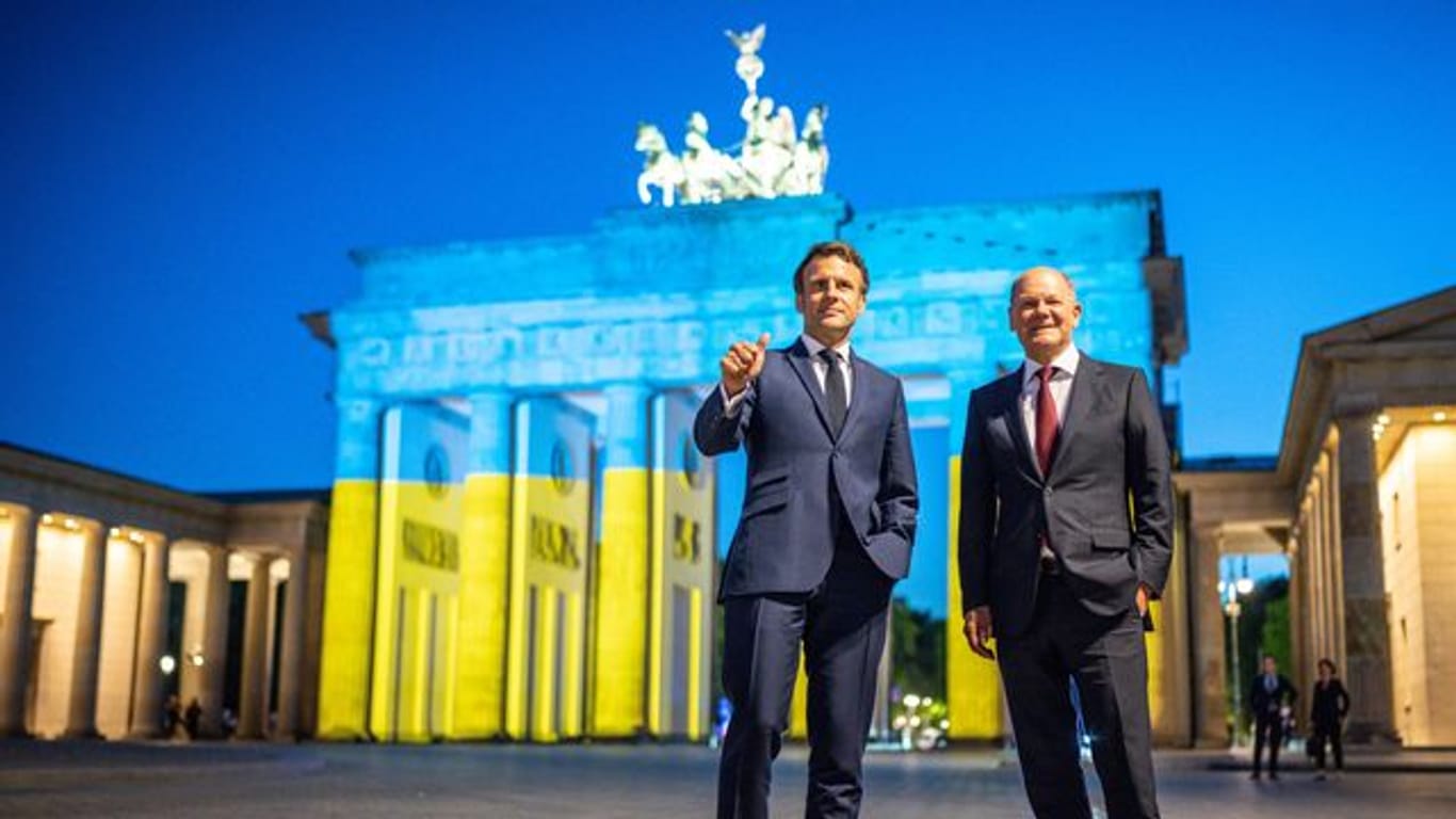 Bundeskanzler Olaf Scholz und Frankreichs Präsident Emmanuel Macron vor dem Brandenburger Tor.
