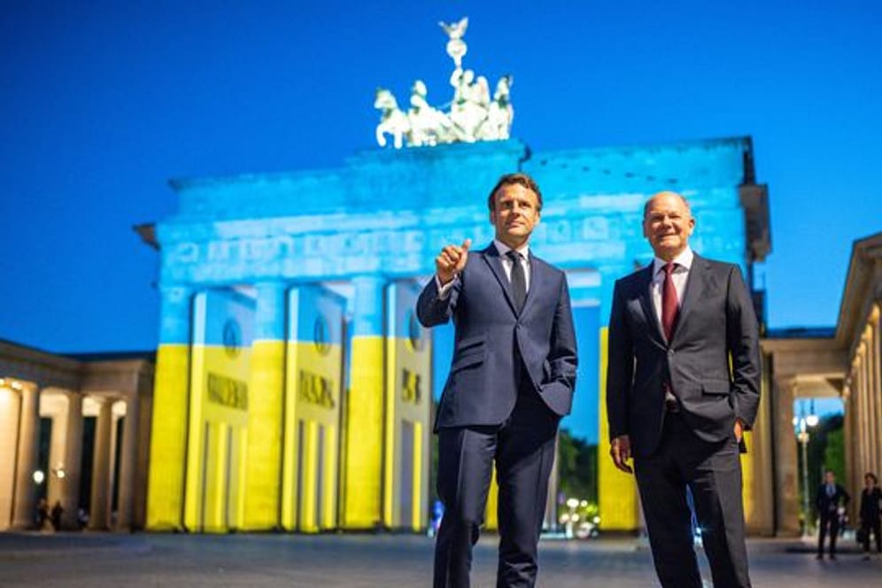 Bundeskanzler Olaf Scholz und Frankreichs Präsident Emmanuel Macron vor dem Brandenburger Tor.