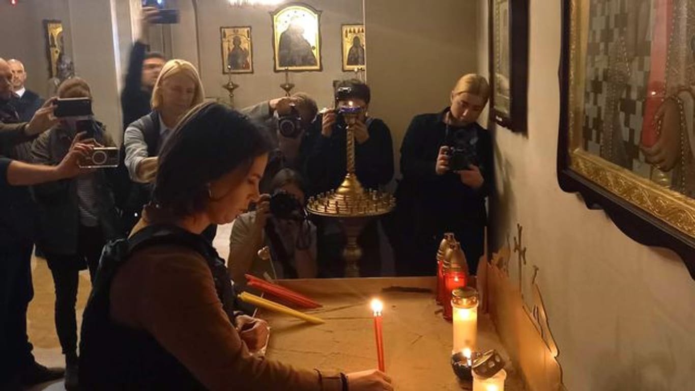 Außenministerin Annalena Baerbock entzündet in einer Kirche in Butscha eine Kerze für die Opfer.