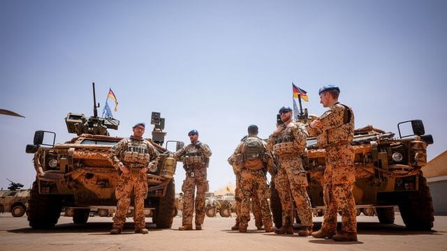 Bundeswehrsoldaten stehen in Gao in Mali im Feldlager Camp Castor an ihren Fahrzeugen.