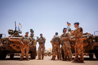 Bundeswehrsoldaten stehen in Gao in Mali im Feldlager Camp Castor an ihren Fahrzeugen.