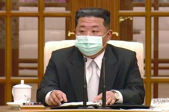 Nordkoreas Machthaber Kim Jong-un trägt während eines Treffens zum ersten Corona-Fall im Land einen Mund-Nasen-Schutz.