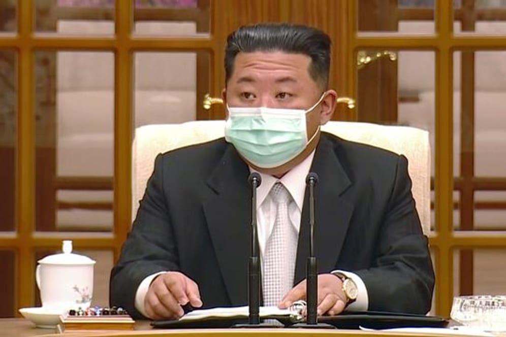 Nordkoreas Machthaber Kim Jong-un trägt während eines Treffens zum ersten Corona-Fall im Land einen Mund-Nasen-Schutz.