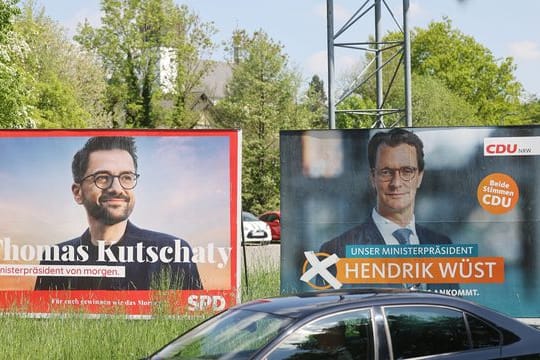 Wahlplakate mit Portraits von Ministerpräsident Hendrik Wüst (r) und Herausforderer Thomas Kutschaty von der SPD.