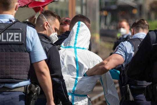 Polizisten führen den mutmaßlichen Täter ab.