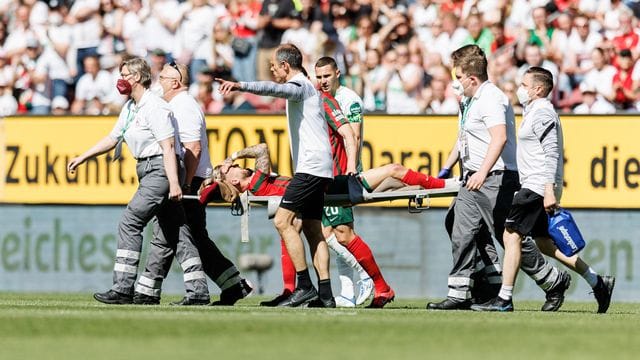 Augsburgs Niklas Dorsch wird verletzt vom Platz getragen.