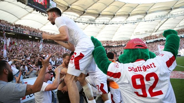 Der Stuttgarter Atakan Karazor (l) feiert mit den Fans das späte Tor zum 2:1 durch Endo.