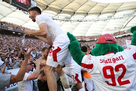 Der Stuttgarter Atakan Karazor (l) feiert mit den Fans das späte Tor zum 2:1 durch Endo.