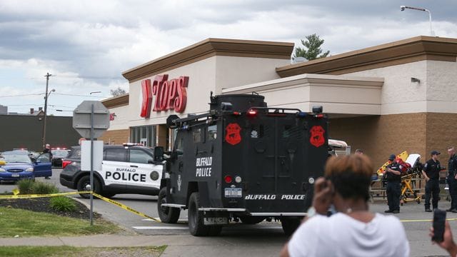 Polizisten stehen nach Schüssen in einem Supermarkt vor dem Geschäft. Polizisten stehen nach Schüssen in einem Supermarkt vor dem Geschäft.