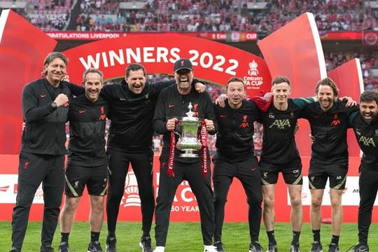 Liverpools Coach Jürgen Klopp (M) feiert den Gewinn des FA Cups mit seinem Trainerteam.