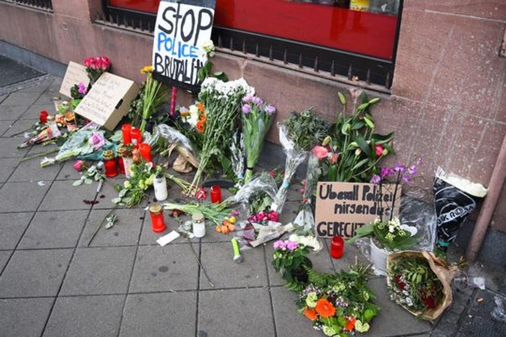 Blumen, Kerzen und Schilder liegen und stehen an dem Ort, an dem am 02.