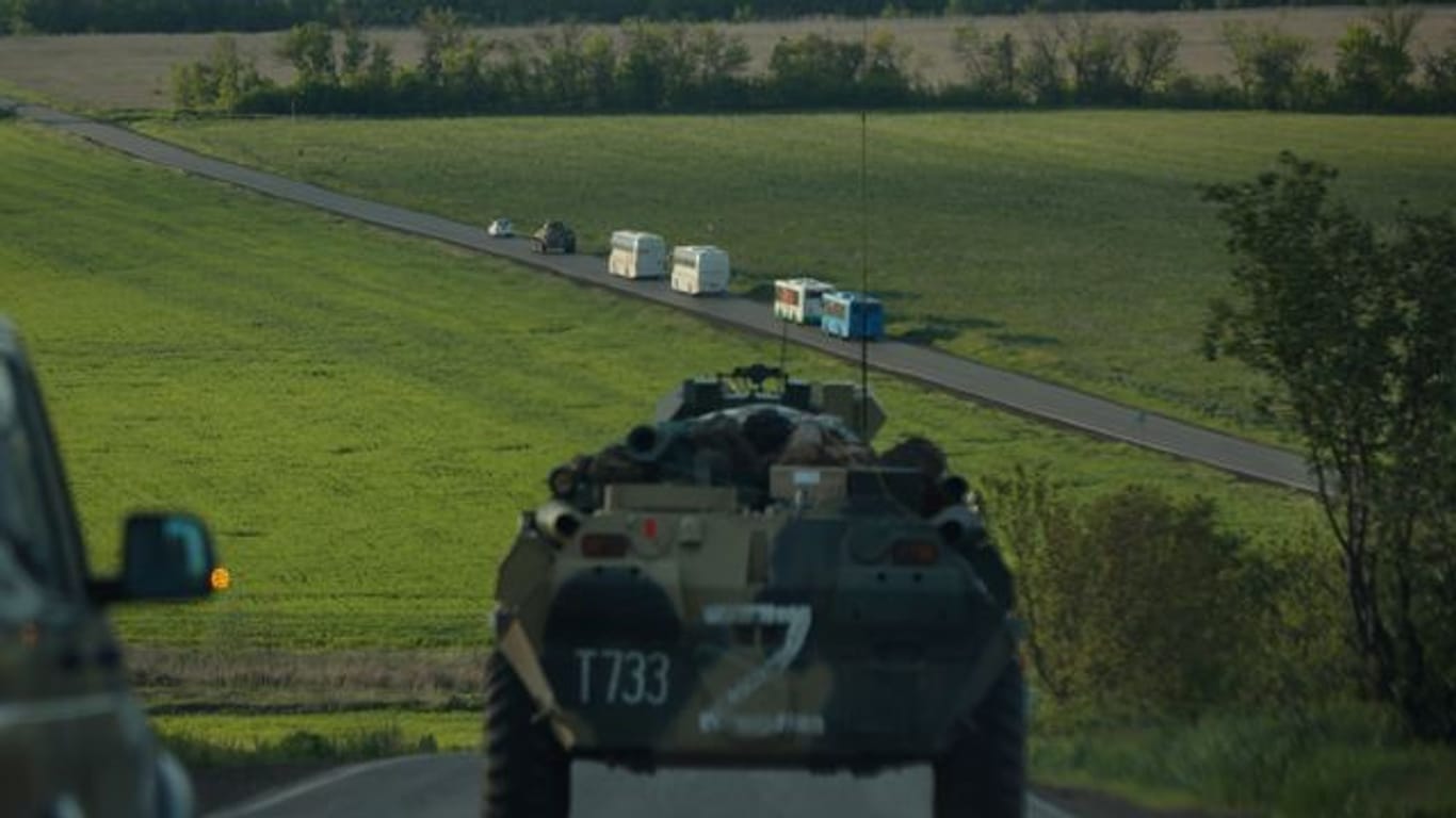 Busse mit ukrainischen Soldaten, die aus dem belagerten Stahlwerk Azovstal in Mariupol evakuiert wurden, fahren in Begleitung russischer Militärfahrzeuge zu einem Gefängnis in der "Volksrepublik" Donezk.