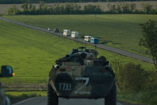 Busse mit ukrainischen Soldaten, die aus dem belagerten Stahlwerk Azovstal in Mariupol evakuiert wurden, fahren in Begleitung russischer Militärfahrzeuge zu einem Gefängnis in der "Volksrepublik" Donezk.