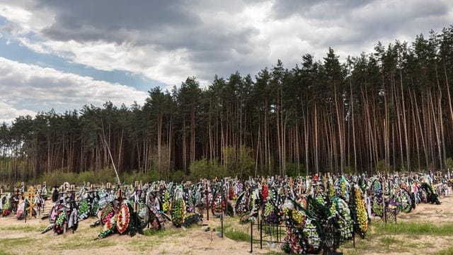 Zahlreiche Blumen und Fotos erinnern an frischen Gräber auf dem Friedhof in Irpin an dort begrabene Einwohner und Mitglieder der Territorialverteidigung, die bei der russischen Invasion in der Ukraine getötet wurden. Zahlreiche Blumen und Fotos erinnern an frischen Gräber auf dem Friedhof in Irpin an dort begrabene Einwohner und Mitglieder der Territorialverteidigung, die bei der russischen Invasion in der Ukraine getötet wurden.