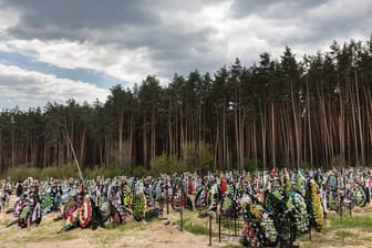Zahlreiche Blumen und Fotos erinnern an frischen Gräber auf dem Friedhof in Irpin an dort begrabene Einwohner und Mitglieder der Territorialverteidigung, die bei der russischen Invasion in der Ukraine getötet wurden.